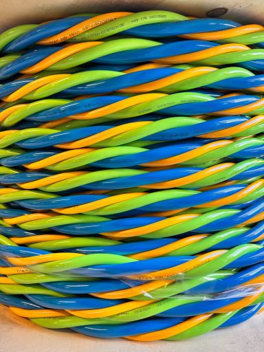 Bunte Schlauchleine für Taucher in Blau, Gelb und Grün, aufgerollt auf einer Trommel.