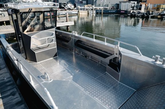 Metallisches Boot mit offenem Steuerstand am Dock.