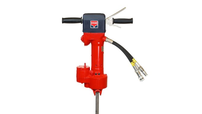 Ein roter hydraulischer Bohrhammer mit Schlauchanschlüssen und Handgriffen.