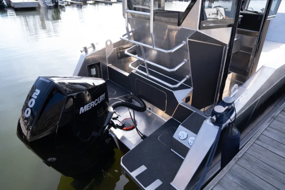Detailansicht eines Bootes mit einem Außenboardmotor und einem stabilen Deck.